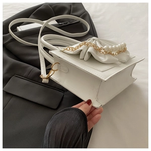 Détail du sac à bandoulière blanc avec nœud en perles élégant et cuir à froufrous