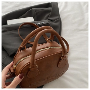 Detail of brown vintage Boston bag with embossed logo on soft textured leather