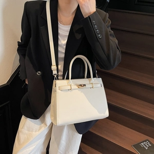 Elegant off-white textured Kelly style handbag with top handle and crossbody strap