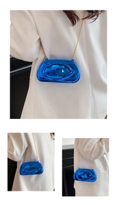 Détail du sac bandoulière bleu métallisé brillant avec chaîne dorée et effet miroir