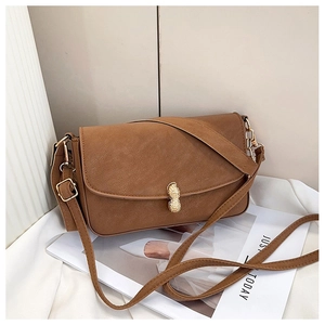 Close-up of brown matte leather shoulder bag featuring a gold peanut-shaped metal buckle