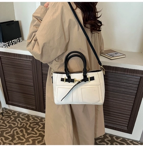 Detail of retro cream and black shoulder bag with gold metal buckles and side view