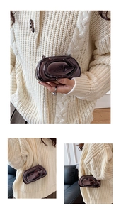 Détail d'une pochette en acrylique marron brillant avec chaîne dorée et design noué