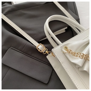 Vue détaillée du sac en cuir plissé blanc avec chaîne dorée et boucle métallique