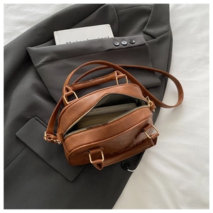 Detail view of the retro brown leather bag interior showing capacity with a smartphone