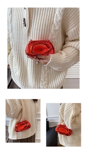 Vue détaillée du sac sculptural rouge métallisé avec une fine bandoulière chaîne dorée