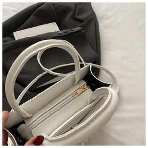 Vue intérieure du sac à main en cuir blanc montrant l'espace et la poche zippée