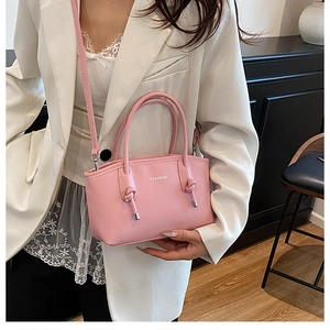 Détail d'un sac à main en cuir PU rose avec sangle à nœud et texte blanc fashion