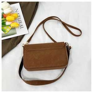 Detail of vintage brown shoulder bag with fine leather texture and gold hardware
