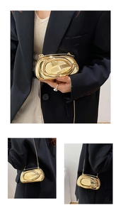Détail de pochette de soirée dorée avec finition miroir brillant et chaîne fine