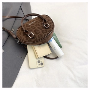 Internal capacity of leopard print crossbody bag showing phone and cosmetics