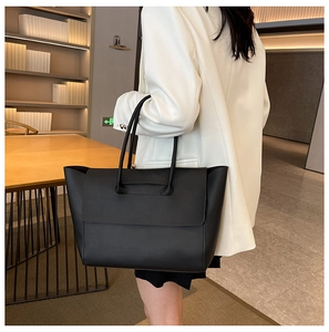 Dettaglio di una grande borsa tote nera opaca con cuciture di qualità e manico integrato