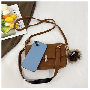 Brown vintage baguette bag with gold peanut buckle shown next to phone for size