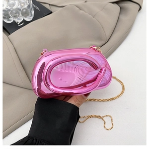 Détail du sac bandoulière rose métallisé avec poignée ovale et chaîne dorée fine