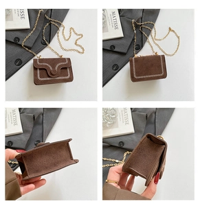 Detail view of brown suede mini bag with white baseball stitching and gold chain strap