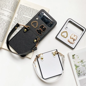 Flat lay of Samsung Z Flip leather case with bear charm and portable handle strap
