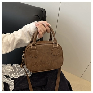 Detail of coffee brown mini handbag with COIH'2DN embossed logo and leather texture