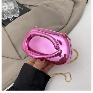 Détail d'une pochette rose métallisée avec poignée creuse et fine chaîne dorée