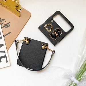 Detail of Saffiano leather phone case for Samsung Flip series with gold bear and heart charm