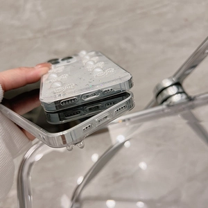 Détail de la coque iPhone avec perles 3D en résine et paillettes argentées sur fond clair