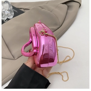 Détail de la pochette cœur rose métallisé brillant avec bandoulière chaîne dorée