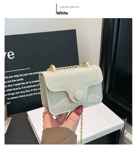 Detail of white lychee pattern leather wallet featuring wavy stitching and gold chain strap