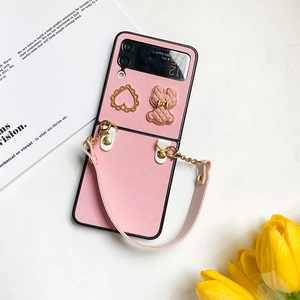 Close-up of pink Z Flip leather case with 3D bear charm and golden heart detail