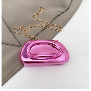 Détail d'une pochette en acrylique rose métallisé avec poignée ronde et chaîne dorée