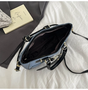 Detail of blue denim fabric texture and golden metal buckle on the women's square bag