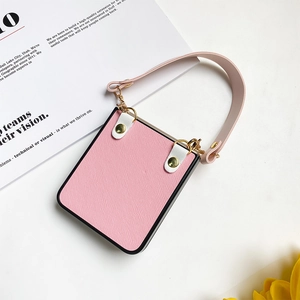 Detailed close-up of pink textured flip phone case with leather handle and gold hardware