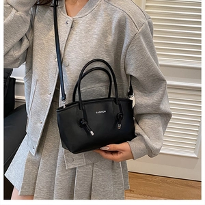 Détail du sac à bandoulière noir avec lettrage FASHION blanc et poignées nouées