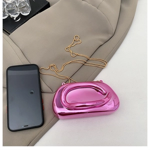 Détail de la pochette rose métallique irrégulière avec sa chaîne dorée sophistiquée