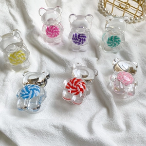 Détails de supports de téléphone ours en résine avec sucettes colorées sur tissu blanc