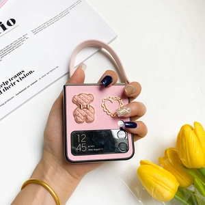 Close-up of pink Z Flip folding phone case featuring a bear motif and a handy strap