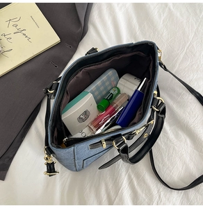 Internal view of blue canvas shoulder bag showing capacity for lipstick and makeup