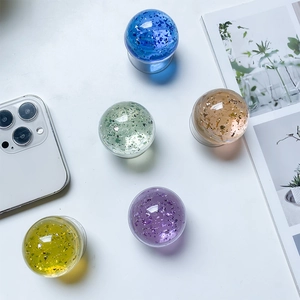 Close-up of colorful crystal ball phone grips with sparkling glitter and clear base
