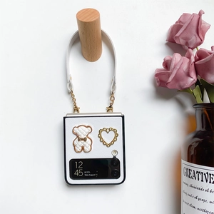 Detail of white leather Samsung Z Flip case with cute 3D bear and gold heart strap