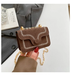 Detailed close-up of brown suede mini square bag with white wheat embroidery and gold chain
