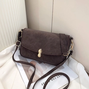 Retro dark brown crossbody bag with unique gold peanut clasp on white fabric