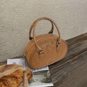 Brown suede round handbag with top handles and silver zipper for elegant women's travel