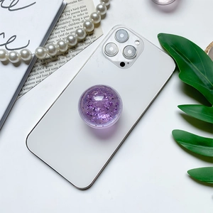 Detail of a purple glitter phone grip with metallic flakes on a white smartphone