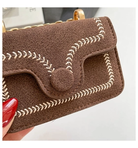 Detail of brown suede crossbody bag featuring elegant wheat embroidery and gold chain strap