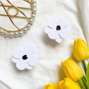 Detail of white flower phone grip with black center on elegant linen background