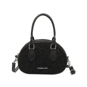 Minimalist black leopard print bowling bag with round handles and adjustable shoulder strap