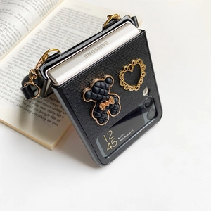 Detail of Galaxy Z Flip case with 3D bear charm, gold heart and leather chain strap