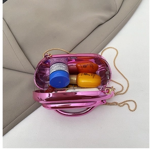 Détail de l'intérieur d'une pochette rose fuchsia miroir avec bandoulière dorée