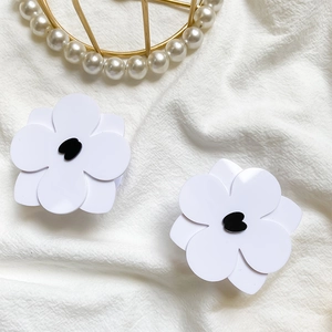 Detailed view of floral phone grip featuring white petals with a black heart center