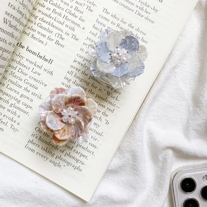 Detail of floral pop socket with pearls on blue and pink gradient petals and soft texture