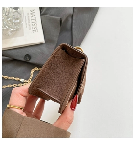 Detail of brown suede mini bag featuring contrast stitching and golden chain strap