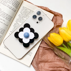 Coque iPhone blanche avec support fleur noire sur livre vintage et tulipes jaunes